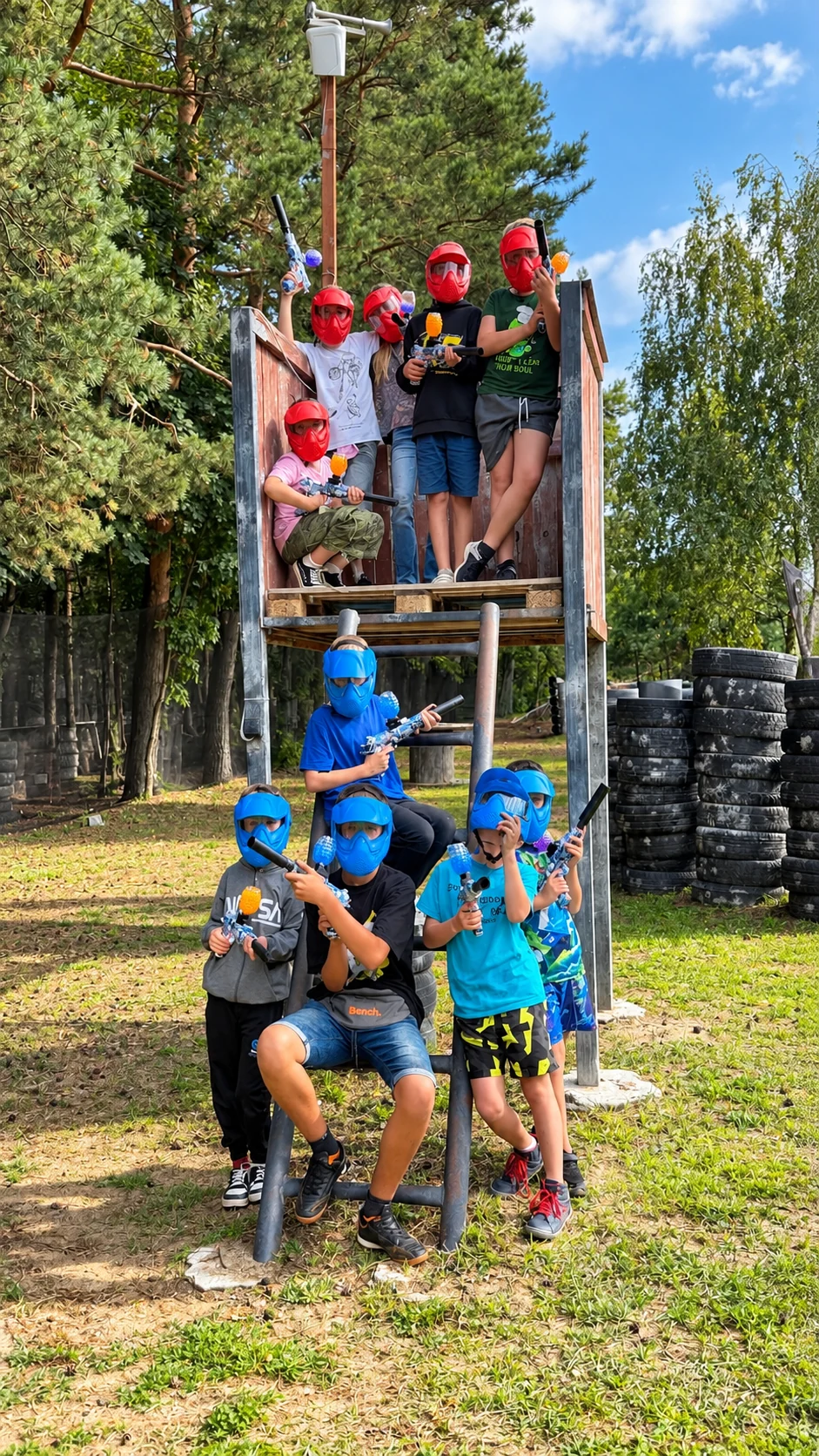 Grupa dzieci w maskach Gel Blaster na drewnianej wieżyczce Paintball Sierpc